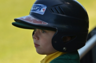little boy in baseball helmet